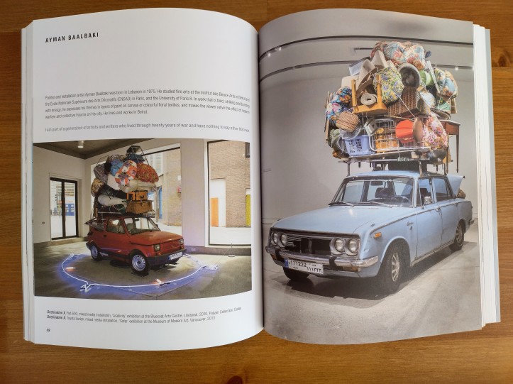 iew of book Arabicity showing photographs of two art installations by artist Ayman Baalbaki. On the left page a small red car with a large pile of luggage on the roof, around the car on the floor is a blue neon circle. On the right page a larger light blue car with a pile of luggage on the roof. 